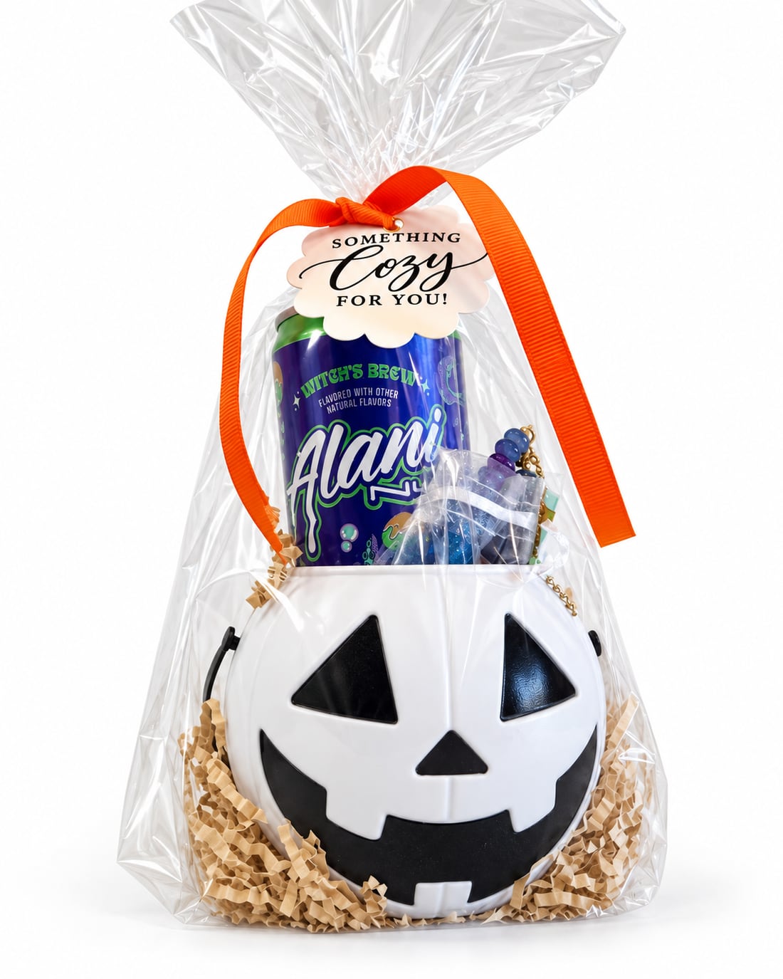 A jack-o'-lantern pail gift wrapped with an orange ribbon and a Something Cozy for you tag
